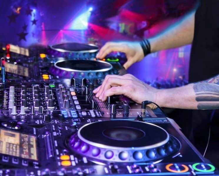 Dj mixes the track in the nightclub at party
