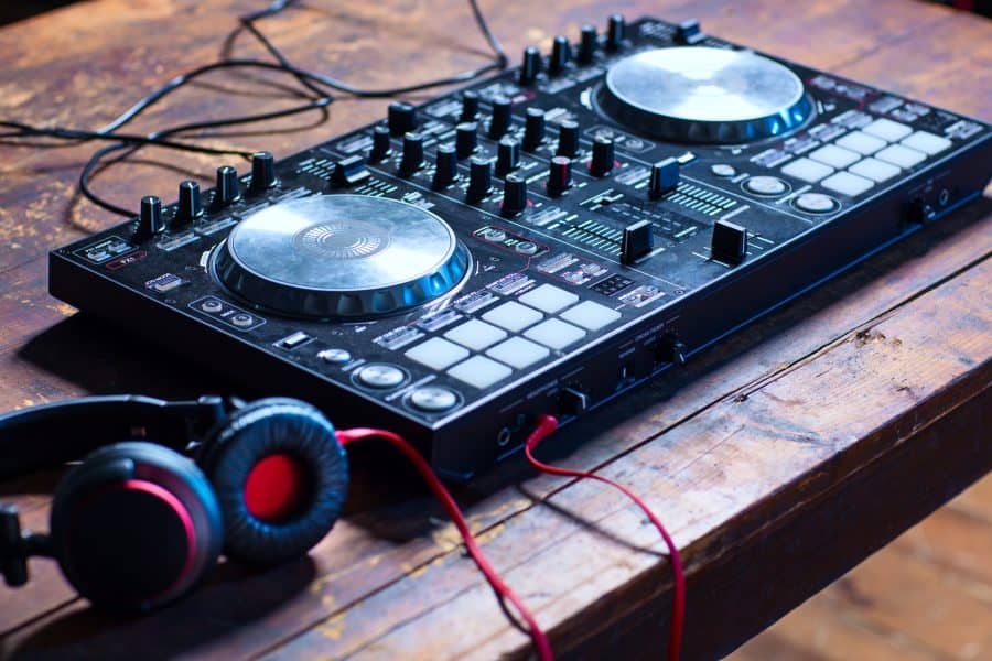 Dj mixer with headphones on wooden table close-up.